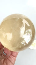 Load and play video in Gallery viewer, Big Rainbows! Honey Calcite Sphere| Optical Honey Calcite | Reiki | Home Decor | Gifts
